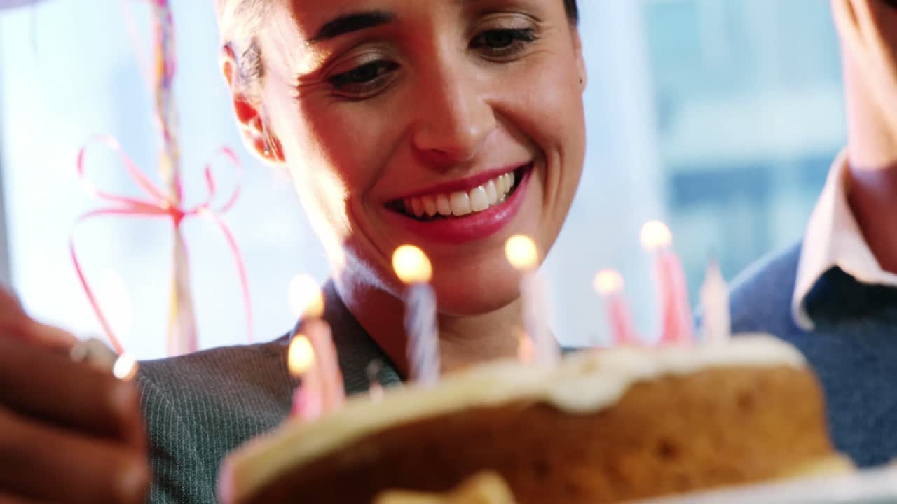 mujer de negocios mirando pastel de cumpleaños
