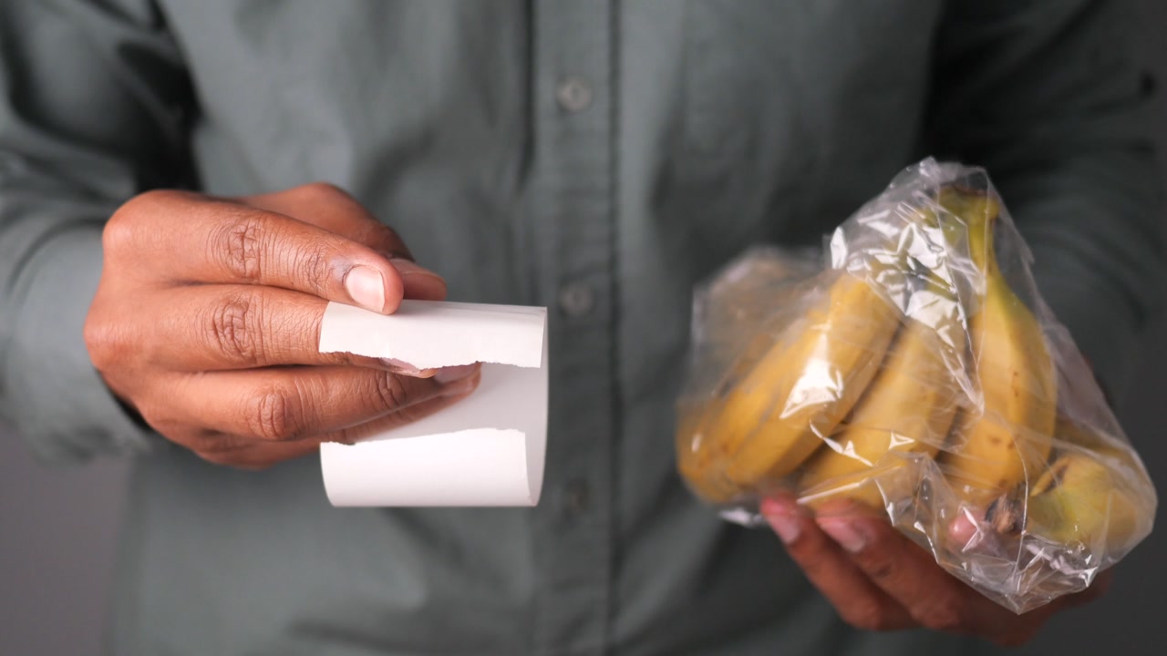 Person Holding Bananas and a Shopping Receipt