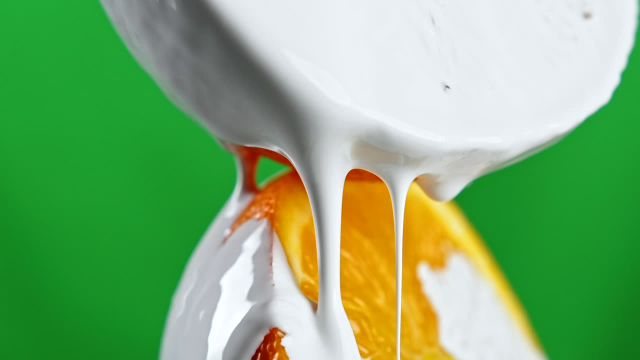 leche chorreando sobre una rebanada de naranja