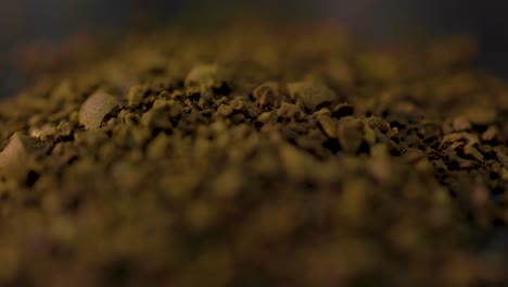 disparo macro de molidos de café que se vierte en la mesa de la cocina