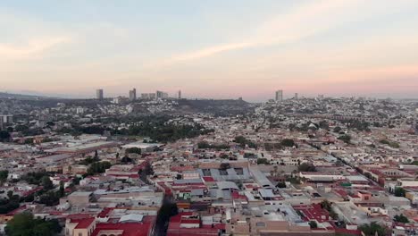 flying over residential houses from mirador de los arcos at dusk in queretaro, mexico