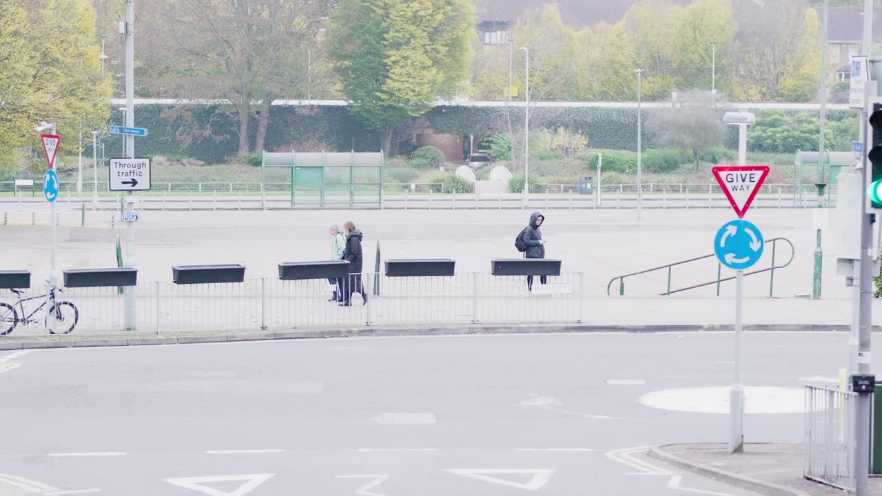 A candid view of the former bus station site in Hemel Hempstead, with people passing by and one person standing with a phone