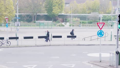 a candid view of the former bus station site in hemel hempstead, with people passing by and one person standing with a phone