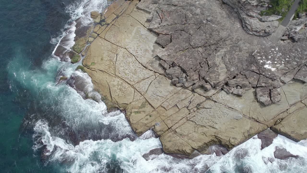las olas del mar chocando contra la costa rocosa de la playa de agua dulce rockpool en nsw, australia