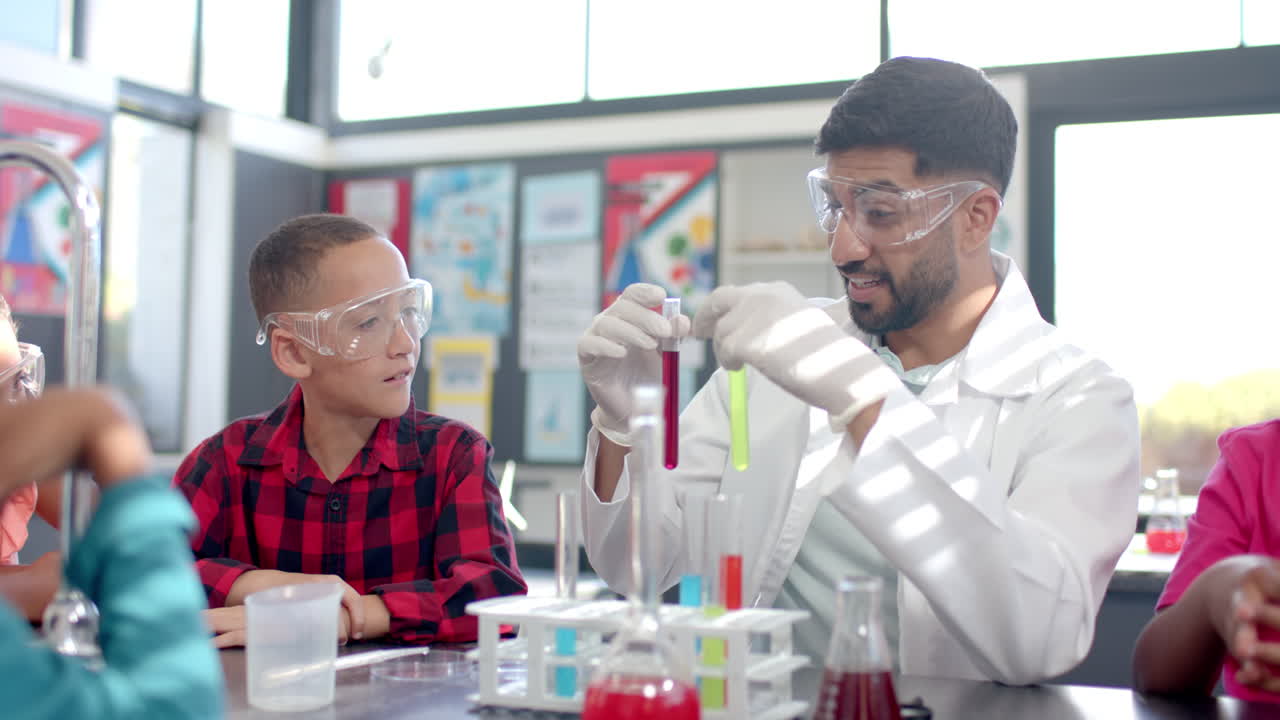In a school classroom, a biracial teacher demonstrates a chemistry experiment