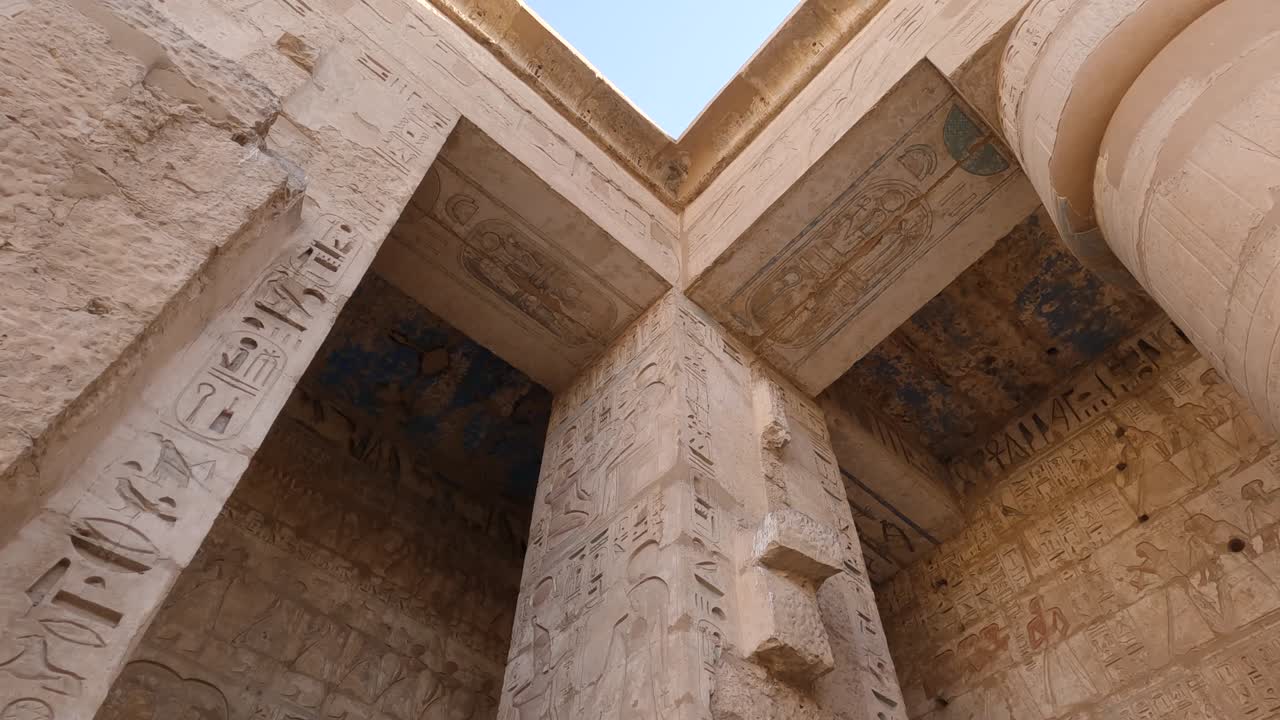 antiguos relieves de pared decorados egipcios y jeroglíficos en columnas y paredes del templo mortuorio de ramses o ramses iii en medinet habu, luxor, egipto