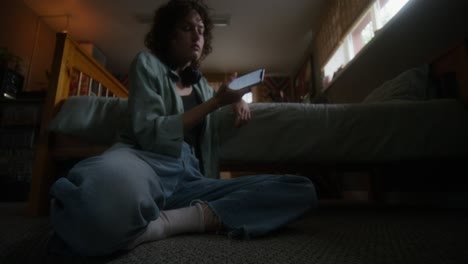 mujer joven relajándose en el dormitorio con el teléfono