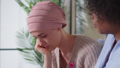 Upset-Young-Woman-Patient-Wearing-Headscarf-Receiving-Chemotherapy-Treatment-For-Breast-Cancer-Being-Comforted-By-Female-Patient