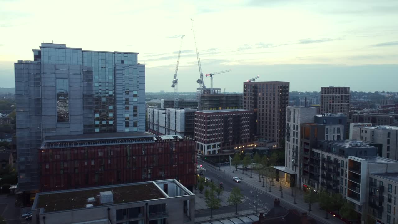 Drone shot flying towards new modern high rise apartments in London