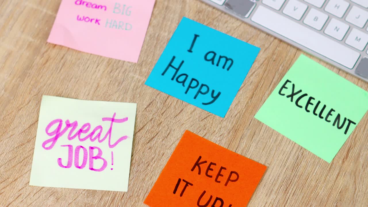 Handwritten inspirational quotes on bright sticky notes arranged on wooden workspace