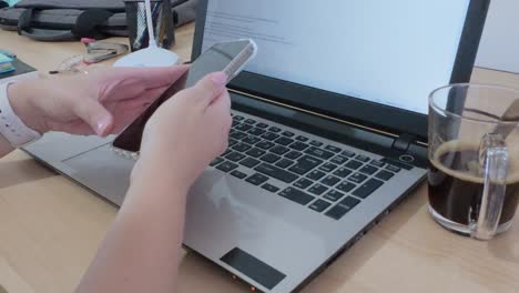 hands focused on typing a document in hebrew on a laptop, coffee fueling productivity.