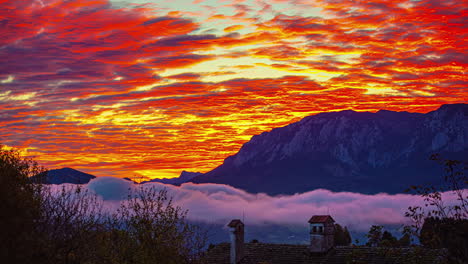 una cubierta de nubes rojas de fuego flota durante la puesta de sol en los alpes austriacos