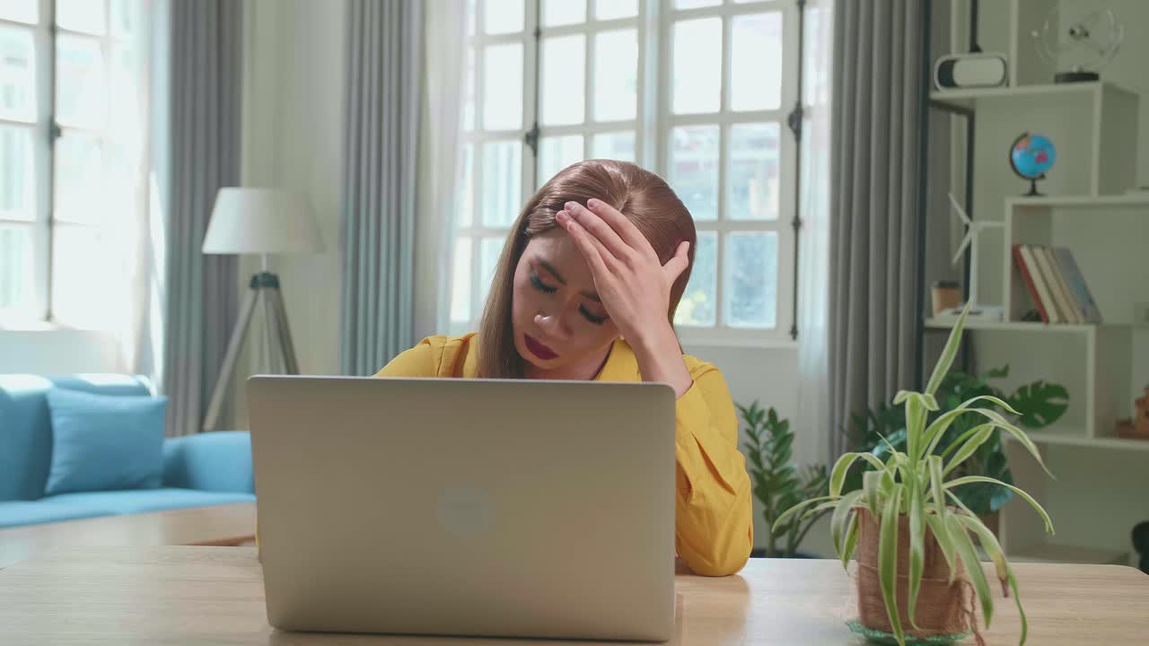 Stressed Asian Young Transgender Woman Working With Laptop Computer In Living Room
