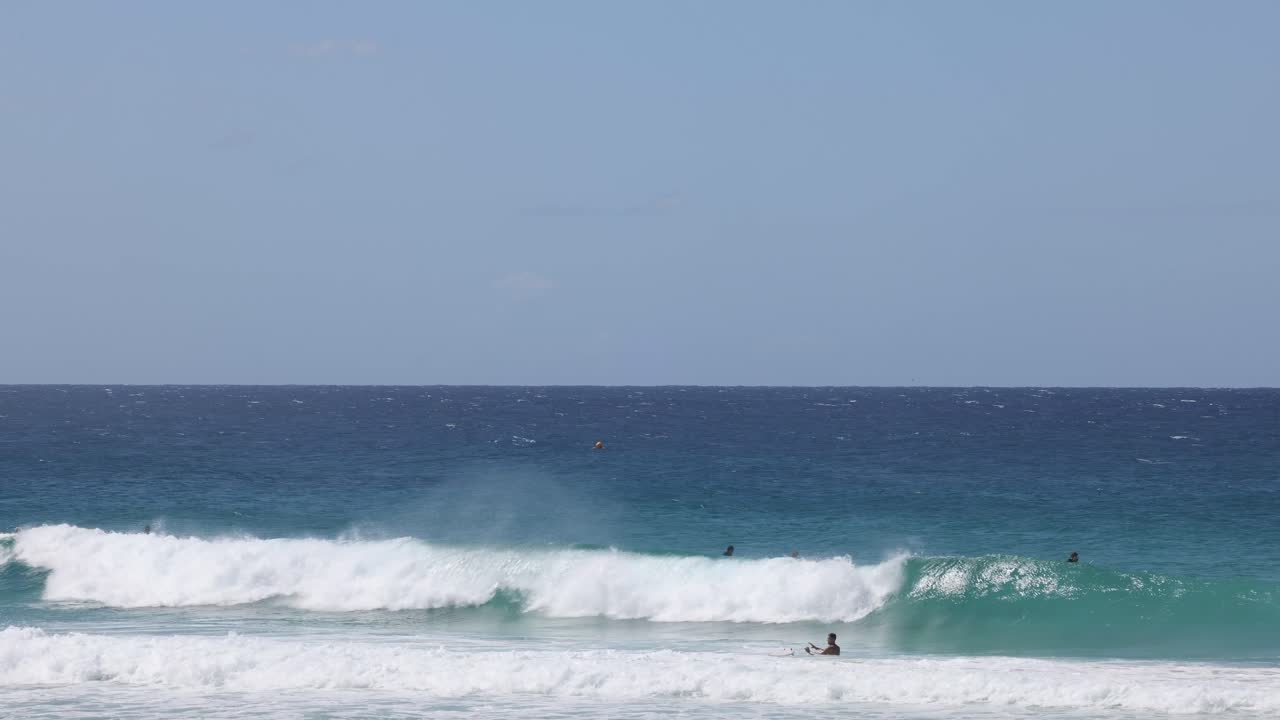 여러 서퍼들이 은 바다에서 파도를 잡습니다.