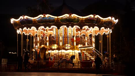 colorful flashing light of vintage carousel carnival fair merry-go-round and silhouette of people