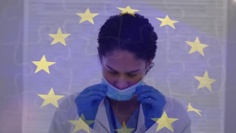 animation of flag of eu over biracial female doctor with face mask