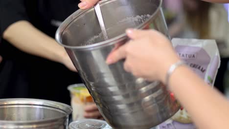 las manos mezclando ingredientes en un recipiente metálico