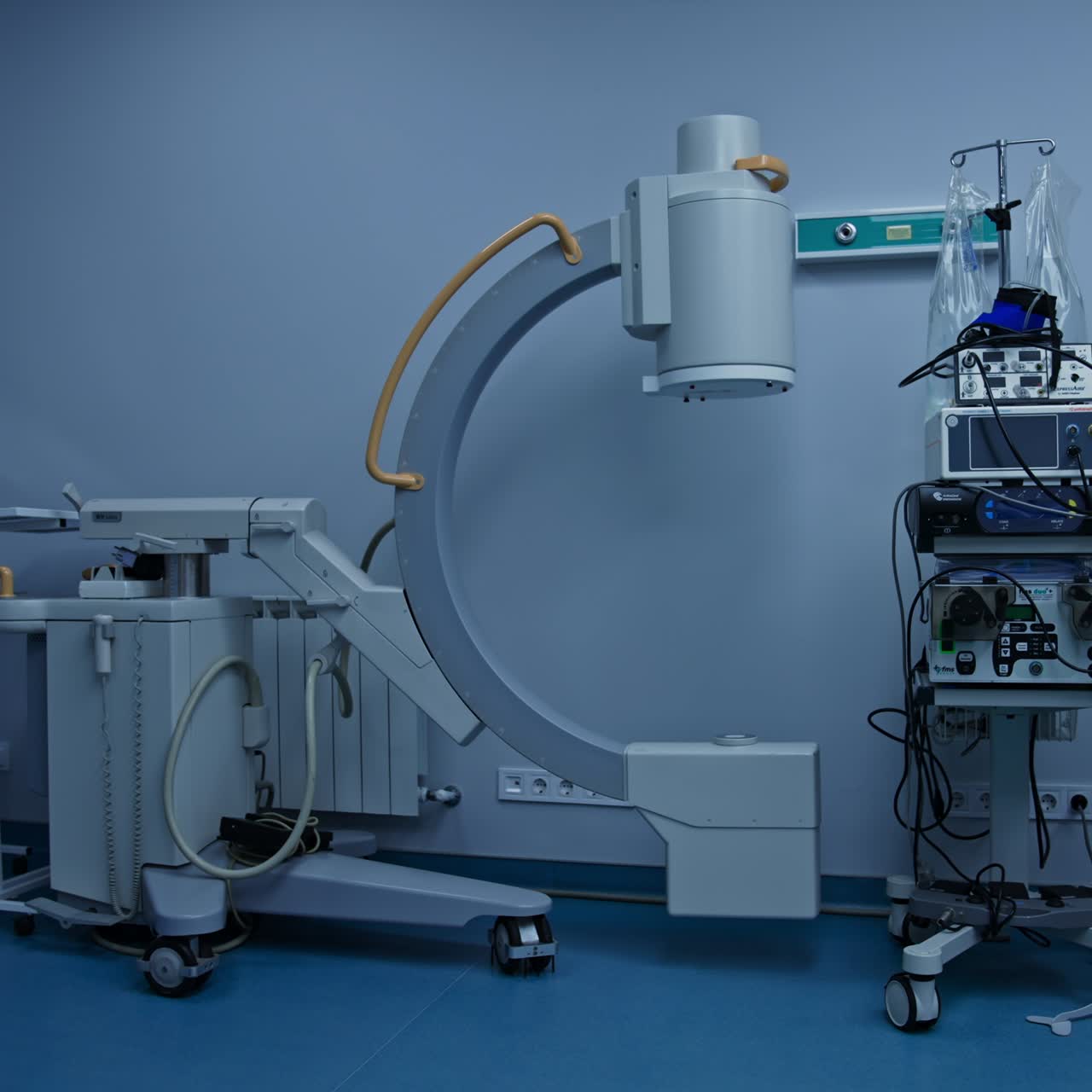 Advanced equipment in spacious modern surgery room. Moving from the C-Arm-Fluoroscopy Machine to operational table