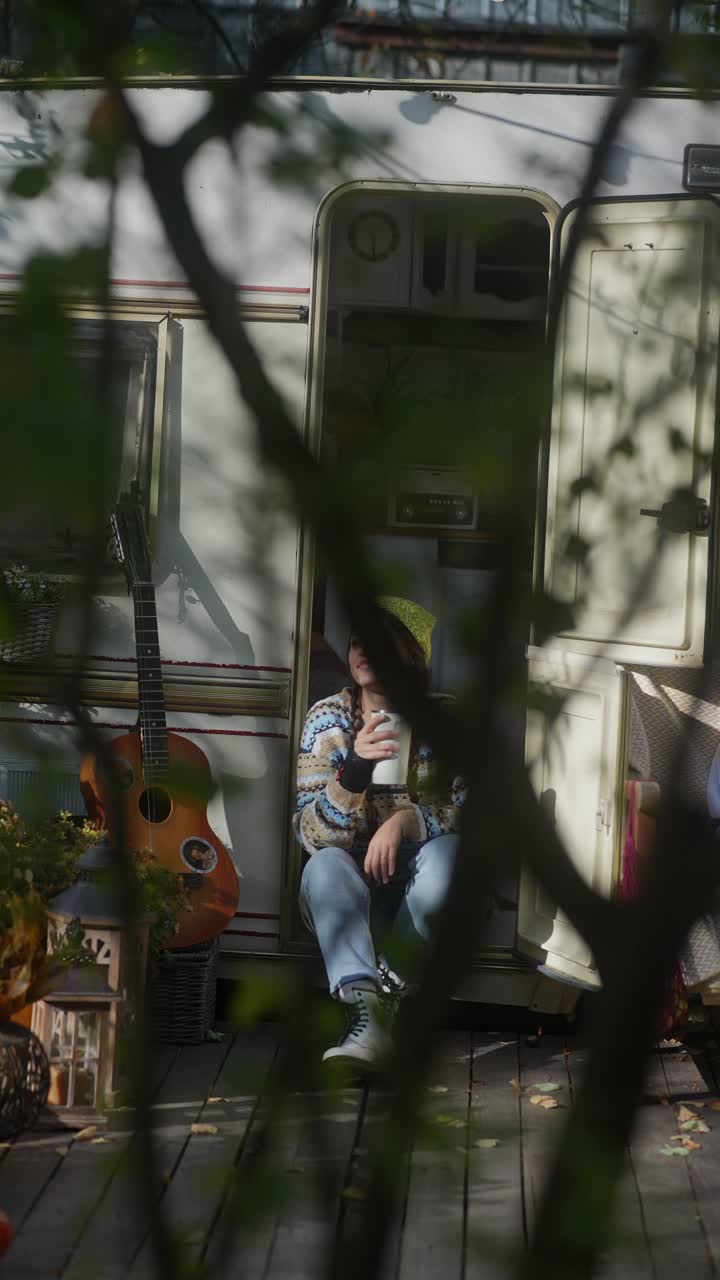 Donna che si rilassa accanto a un camper in autunno