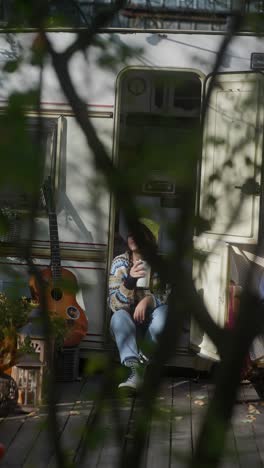 woman relaxing by a camper in autumn