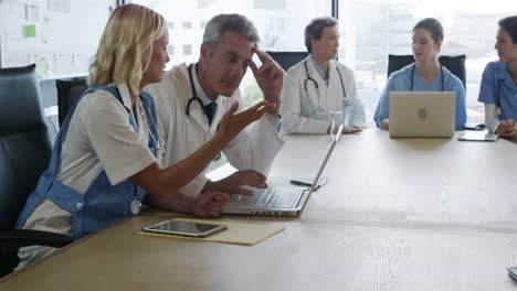 concentrated doctors looking at laptop