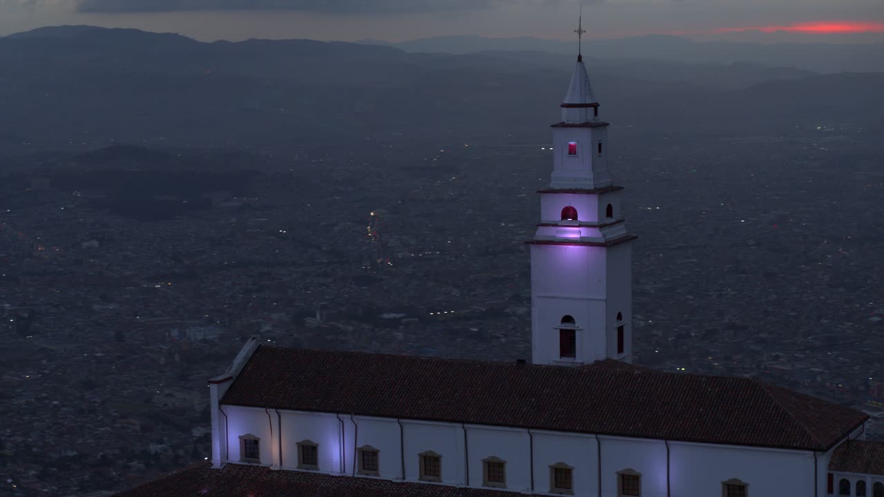 Ripresa con drone della chiesa di Monserrate che domina la città di Bogotà, Colombia, all'ora blu.
