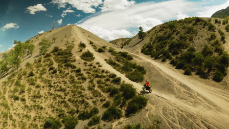 motorcyclist rides uphill overtaking competitor fpv. rider maneuvers on difficult offroad land at extreme racing. feeling of speed and freedom