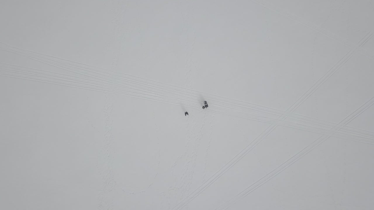 얼어붙은 호수에서 스노우슈를 타고 있는 사람들을 확대합니다.