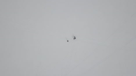 Zooming-into-people-snowshoeing-on-a-frozen-lake