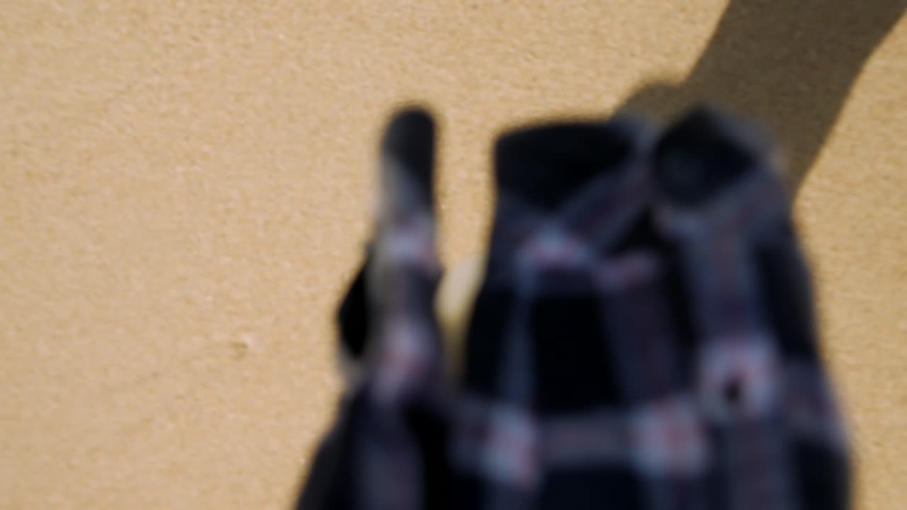 First Person View of Person Walking on Sand with Shadows
