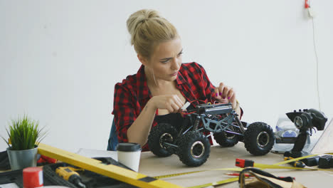 Female-repairing-radio-controlled-car-