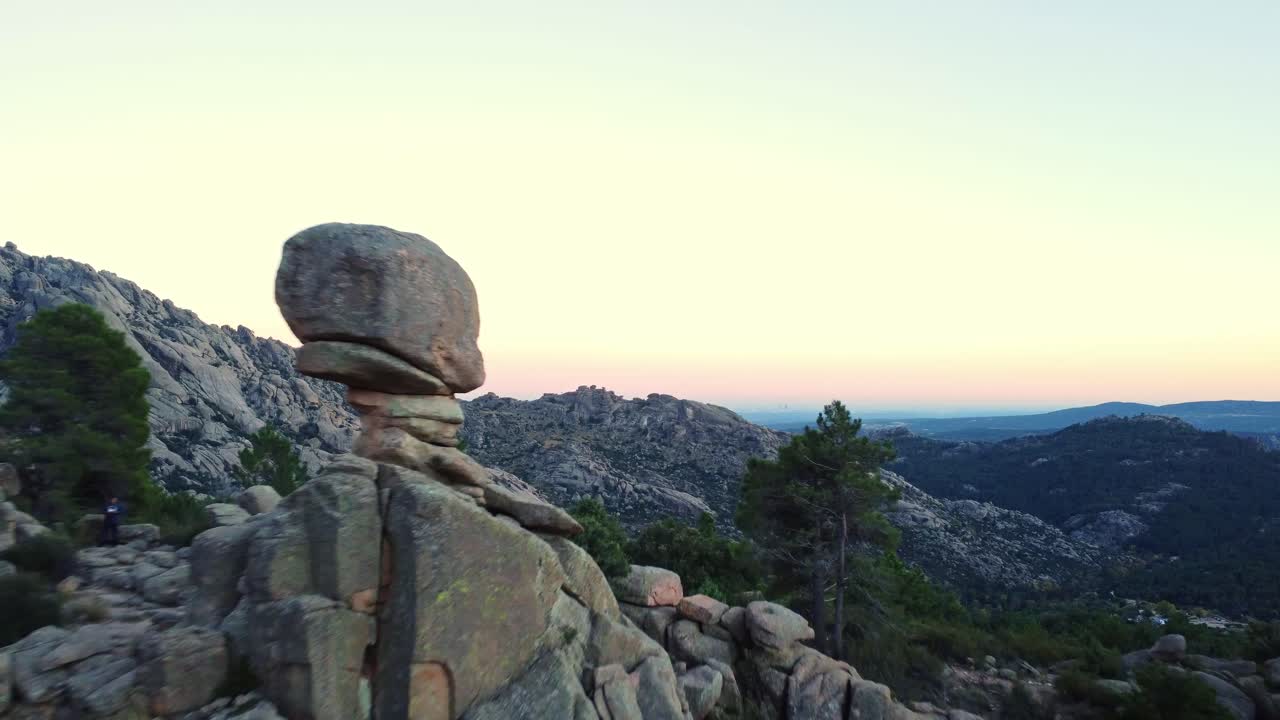 해가 지는 하늘을 배경으로 산꼭대기와 숲