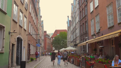 wander through the picturesque streets of gdansk's old town center, where colorful buildings and bustling cafes create a vibrant atmosphere during a summer evening.