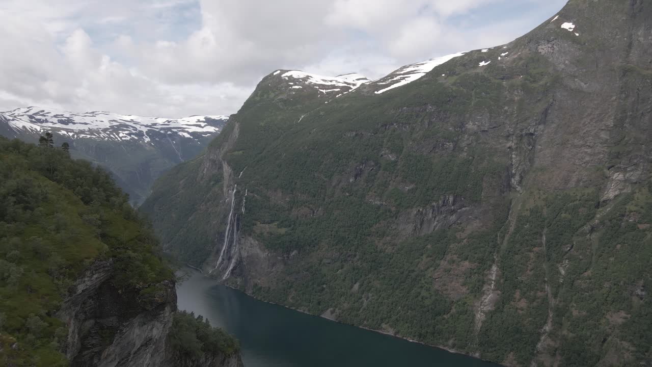 foto de revelação aérea frontal do fiorde de geiranger coberto de neve em um dia nublado, noruega