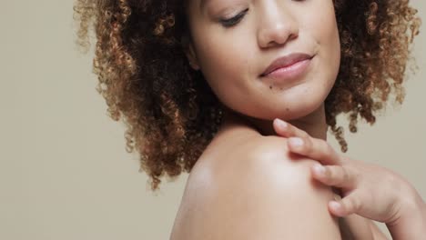 mujer biracial con cabello oscuro en fondo beige con espacio de copia, cámara lenta