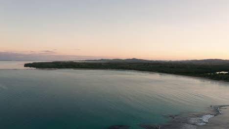 natadola bay in fiji during tranquil sunrise, aerial pan right