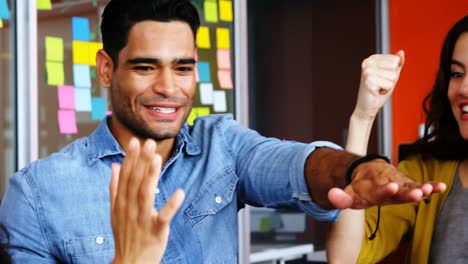 smiling graphic designers forming hand stack together in meeting