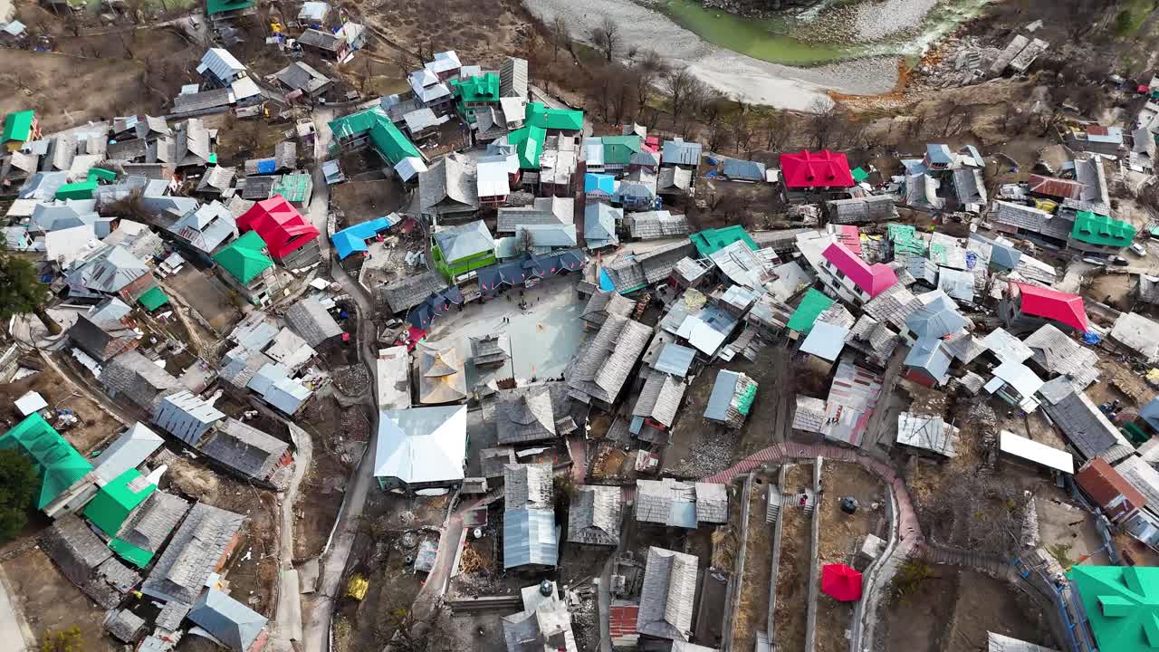 Aerial drone shot of Sangla village with its traditional wooden houses and stunning mountain backdrop.