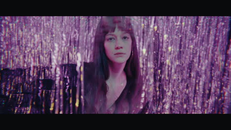woman behind glittery curtains