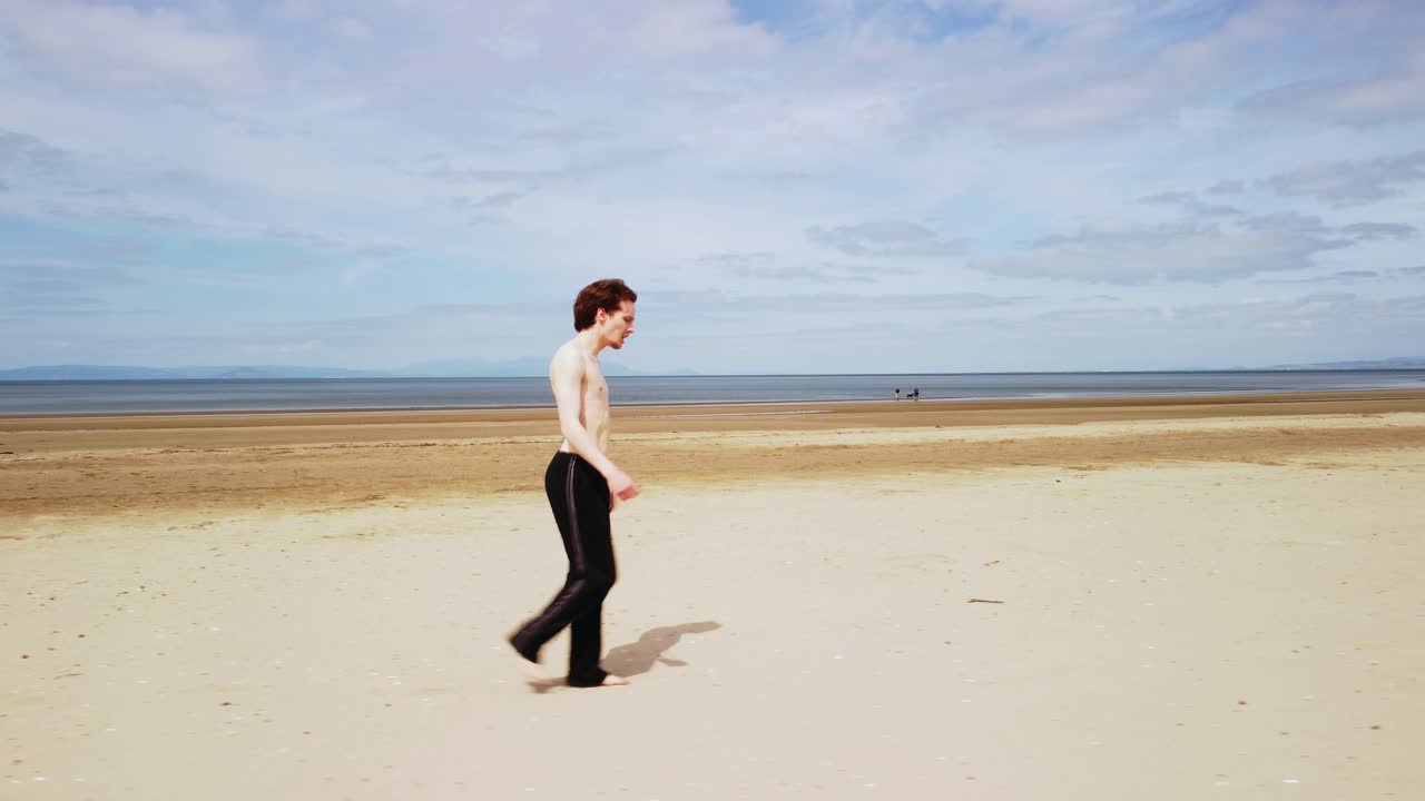 모래 해변에서  ⁇ 고 있는 젊은 셔츠 없는 남자의  ⁇  트래킹  ⁇