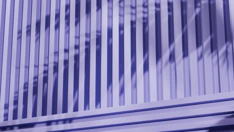 purple metal panels with shadows of tropical leaves. abstract architectural detail. close-up photography with copy space for design and print