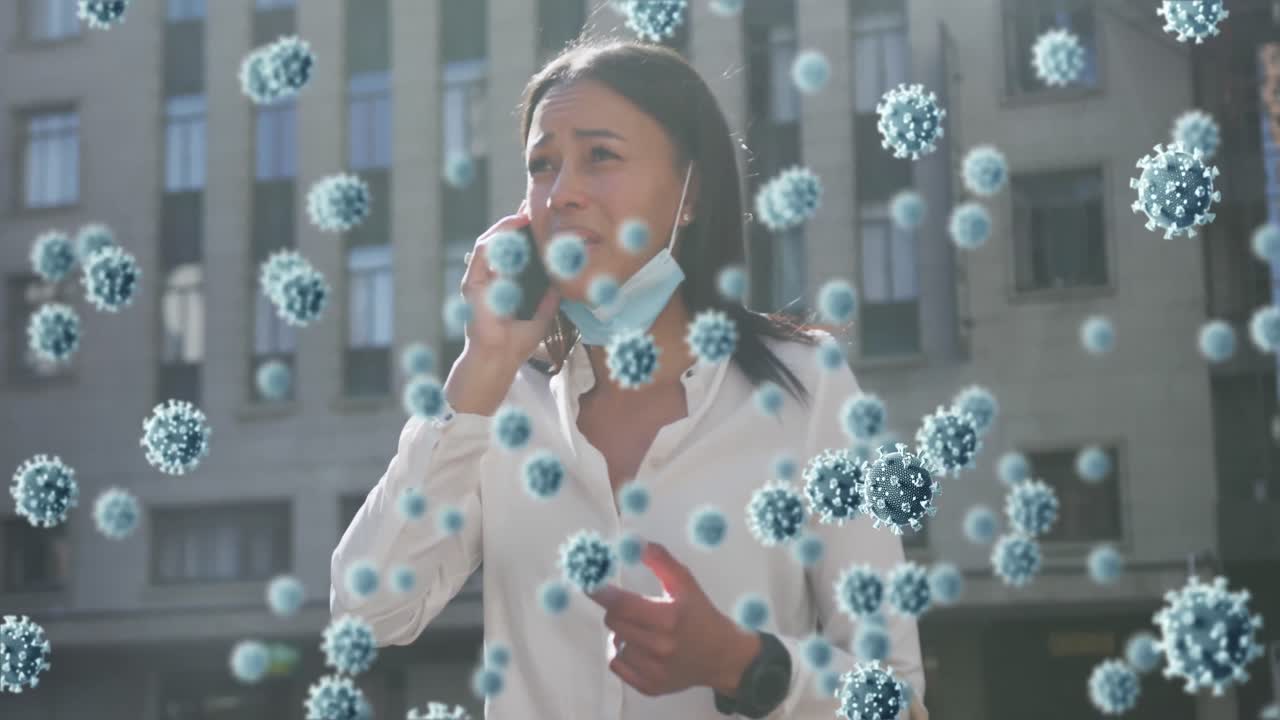 células de covid-19 flotando contra la mujer con la máscara bajada hablando en el teléfono inteligente
