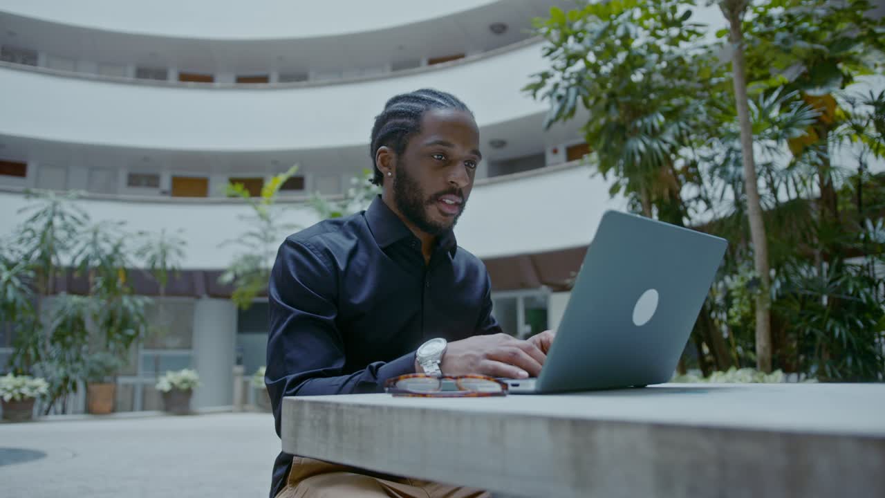 Man working on a laptop in a courtyard