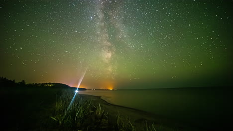 der kern der milchstraße durchquert den nachthimmel über dem atlantik dann färbt das aurora borealis den himmel grün - zeitraffer