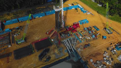 estructura cinematográfica de plataformas de perforación y reacondicionamiento en tierra y equipo de plataformas para la exploración y explotación de petróleo en medio de la jungla rodeada de palmeras durante la puesta de sol