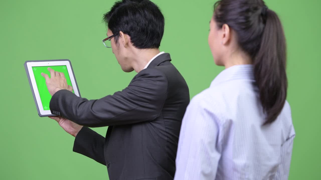Young Asian business couple using digital tablet together