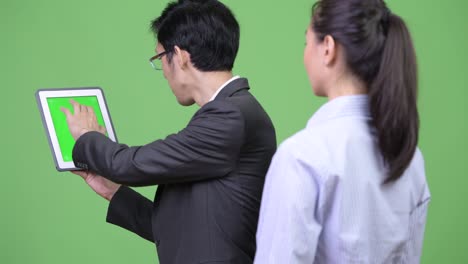 young asian business couple using digital tablet together