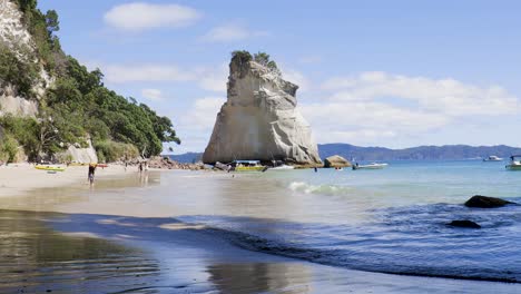 wide shot of waves rolling at te hoho rock and cathedral cove beach