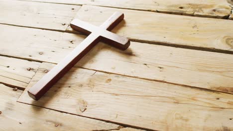 close up of cross on wooden background with copy space