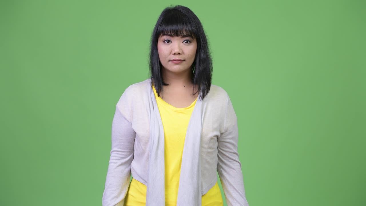 Beautiful happy Asian woman smiling while giving thumbs up